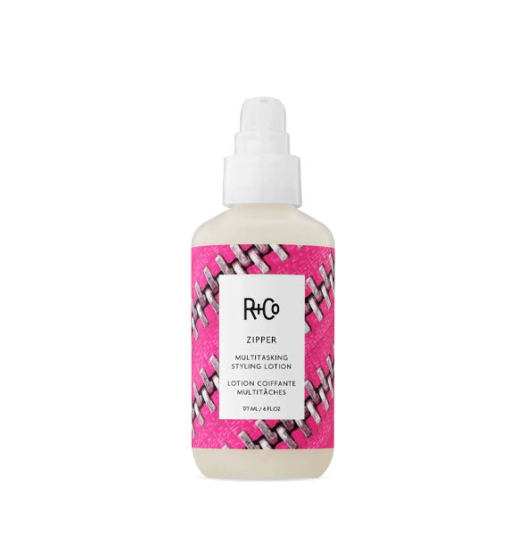6 ounce bottle of R+Co Zipper Multitasking Styling Lotion with pink zipper design on the label